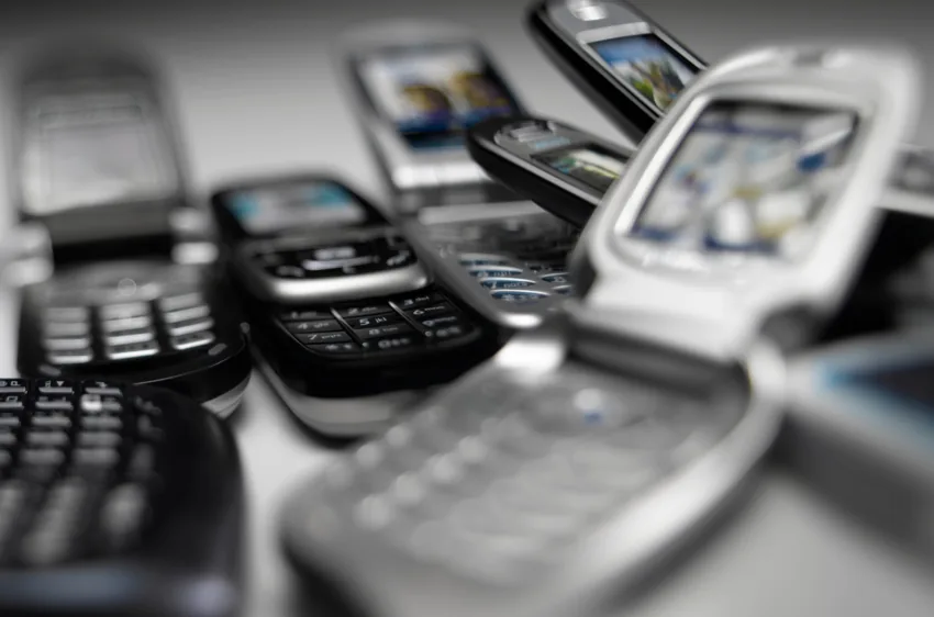 A collection of basic mobile phones with physical keypads.