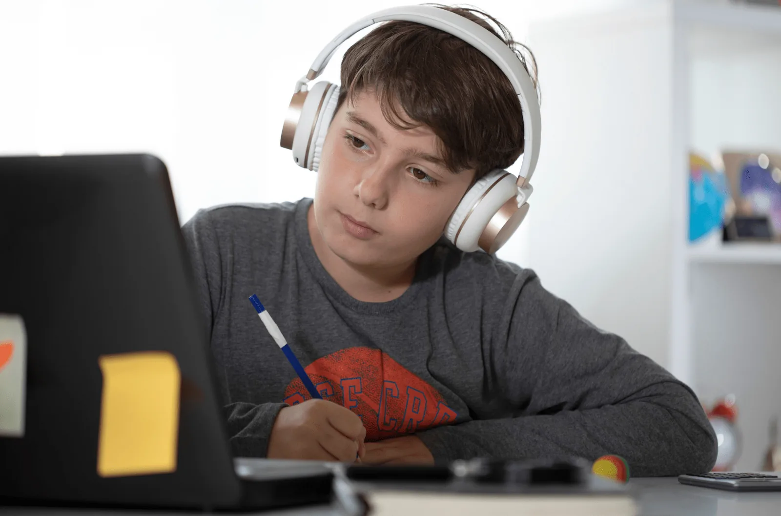 A child using a tablet to study during a home schooling session.